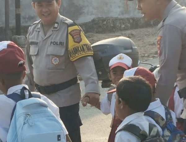 Hadirkan Rasa Aman di Pagi Hari, Kapolsek Alak Bersama Personel Bantu Siswa Menyeberang Jalan.