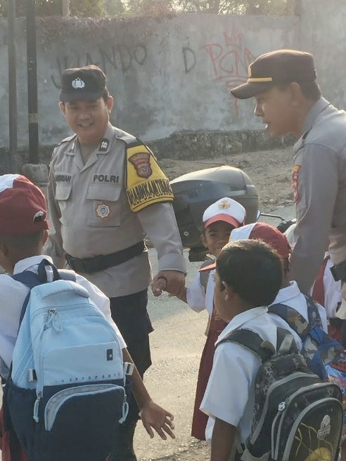 Hadirkan Rasa Aman di Pagi Hari, Kapolsek Alak Bersama Personel Bantu Siswa Menyeberang Jalan.